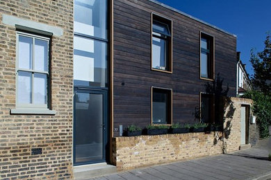 Photo of a medium sized and black contemporary two floor house exterior in Buckinghamshire with wood cladding.