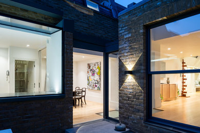 Inspiration for a medium sized and multi-coloured modern brick terraced house in London with three floors, a flat roof and a mixed material roof.