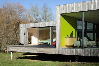 Inspiration for a brown contemporary bungalow detached house in Hampshire with wood cladding and a flat roof.
