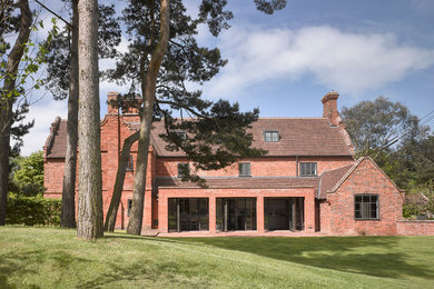 Red and large traditional two floor brick house exterior in London.