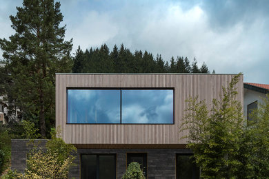 Photo of a brown contemporary two floor detached house in London with mixed cladding and a flat roof.