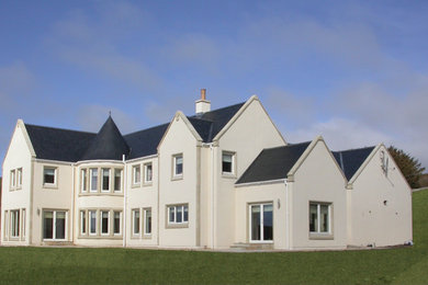 Пример оригинального дизайна: белый, огромный, двухэтажный частный загородный дом в стиле кантри с облицовкой из цементной штукатурки, двускатной крышей и черепичной крышей