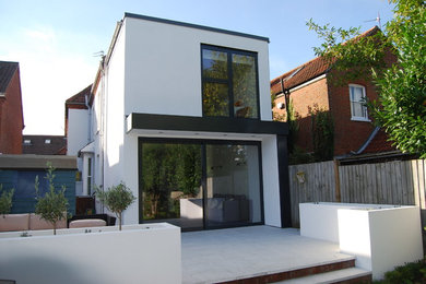 This is an example of a large and white modern two floor render house exterior in Cambridgeshire with a flat roof.