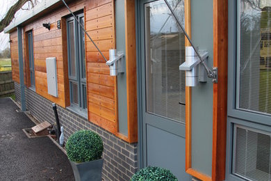 Photo of a medium sized modern bungalow house exterior in Oxfordshire with mixed cladding.