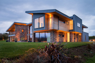 Inspiration for a large contemporary two-story wood house exterior remodel in Cornwall