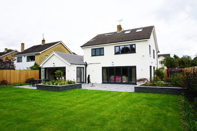 Photo of a large and white contemporary render detached house in Other with a pitched roof, a tiled roof and three floors.