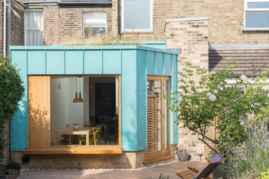 Idee per la facciata di una casa a schiera verde contemporanea a tre piani di medie dimensioni con rivestimento in metallo, tetto piano e copertura verde