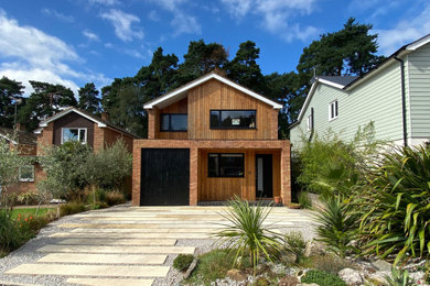 Modelo de fachada de casa multicolor y marrón escandinava de tamaño medio de dos plantas con revestimiento de madera, tejado a dos aguas, tejado de teja de barro y panel y listón