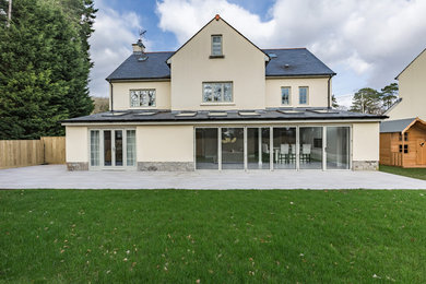 Diseño de fachada de casa blanca contemporánea de tamaño medio de tres plantas con revestimiento de estuco y tejado de teja de barro