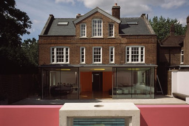 Modelo de fachada roja clásica de tamaño medio de tres plantas con revestimiento de vidrio y tejado a dos aguas