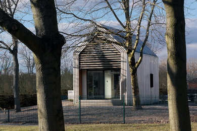 Идея дизайна: деревянный, коричневый дом в современном стиле с двускатной крышей