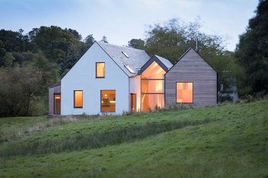 Immagine della villa bianca contemporanea a due piani di medie dimensioni con rivestimento in legno, tetto a capanna e copertura mista
