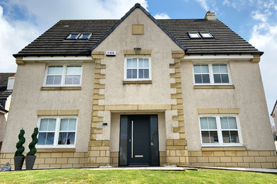Photo of a beige render house exterior in Glasgow with three floors.