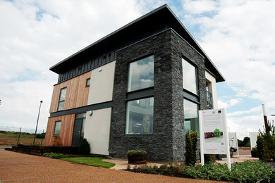 Imagen de fachada de casa multicolor contemporánea de tamaño medio de dos plantas con revestimientos combinados y tejado de un solo tendido