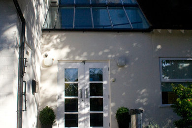 Large and white traditional two floor render house exterior in London with a pitched roof.