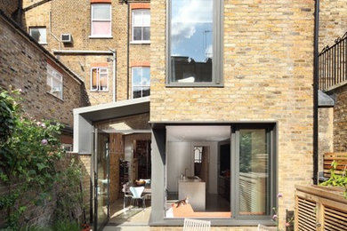 Beige contemporary brick and rear extension in London with a flat roof.