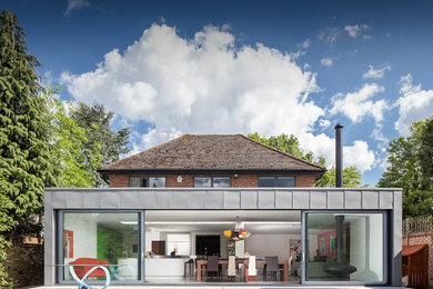 This is an example of a large and white contemporary bungalow brick house exterior in Hertfordshire with a flat roof.