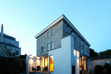 Ejemplo de fachada de casa bifamiliar vintage de tamaño medio con revestimiento de ladrillo y tejado de metal