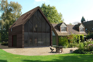 На фото: деревянный, двухэтажный частный загородный дом в стиле модернизм с двускатной крышей с