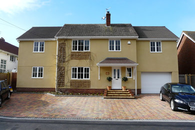 Diseño de fachada de casa beige moderna grande de dos plantas con revestimiento de estuco, tejado a dos aguas y tejado de teja de barro