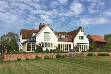 This is an example of a large and white classic two floor render detached house in Other with a pitched roof and a tiled roof.