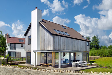 Inspiration for a medium sized and multi-coloured modern detached house in Dorset with mixed cladding, a pitched roof, a tiled roof and three floors.
