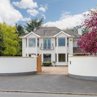 Ispirazione per la villa grande beige moderna a tre piani con rivestimento in stucco e tetto a padiglione