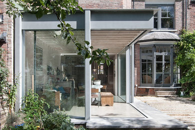 Imagen de fachada de casa pareada gris minimalista de tamaño medio de tres plantas con revestimiento de madera, tejado plano y tejado de varios materiales