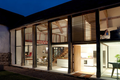 Inspiration for a large and white contemporary two floor detached house in Devon with wood cladding, a pitched roof and a mixed material roof.