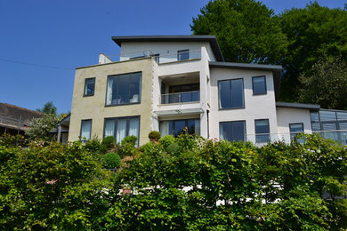 Photo of a large modern house exterior in Dorset with three floors and stone cladding.