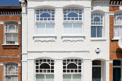 ロンドンにあるトラディショナルスタイルのおしゃれな家の外観 (レンガサイディング、タウンハウス) の写真