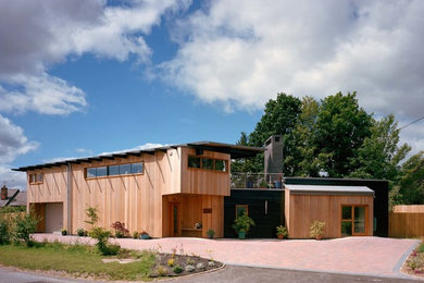 This is an example of a contemporary two floor house exterior in West Midlands with wood cladding.