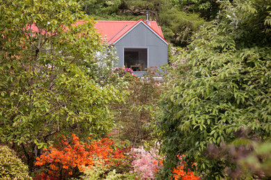 Imagen de fachada de casa gris tradicional renovada de tamaño medio de una planta con revestimiento de metal, tejado a dos aguas y tejado de metal