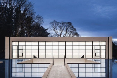 Ispirazione per la villa ampia beige moderna a tre piani con rivestimento in cemento e tetto piano