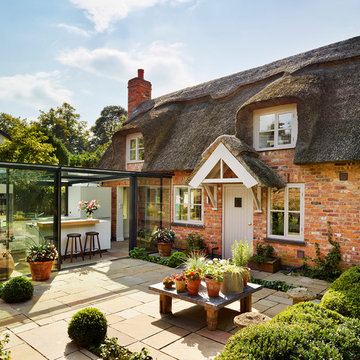 Glass box extension on thatched cottage
