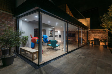 Medium sized contemporary two floor glass detached house in Other with a flat roof.