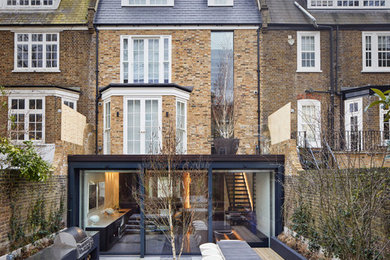 Photo of a medium sized contemporary brick terraced house in London with three floors.