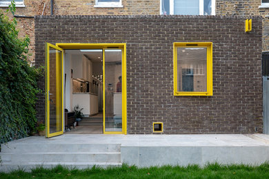 Inspiration for a large and gey modern bungalow brick flat in London with a flat roof.