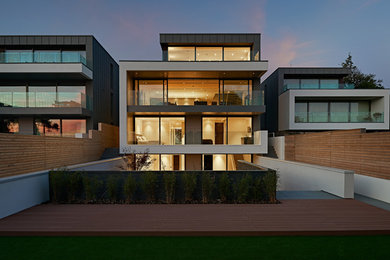 Diseño de fachada multicolor actual grande de tres plantas con revestimientos combinados y tejado plano