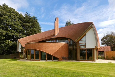Photo of a contemporary brick detached house in Hertfordshire with a tiled roof.