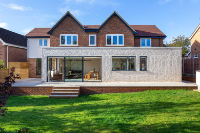 This is an example of a large contemporary two floor brick detached house in Oxfordshire with a pitched roof, a tiled roof and a brown roof.