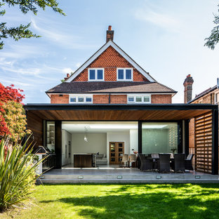 Design ideas for a medium sized and red contemporary two floor detached house in Surrey with mixed cladding, a pitched roof and a shingle roof.