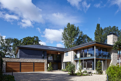 Ejemplo de fachada de casa contemporánea de tamaño medio de tres plantas con revestimientos combinados y tejado a doble faldón
