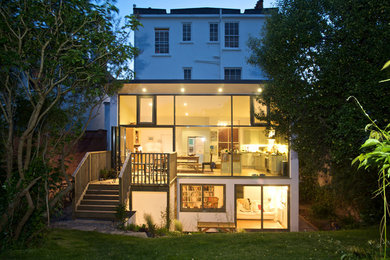 Modelo de fachada blanca contemporánea de tres plantas con revestimiento de vidrio y tejado plano