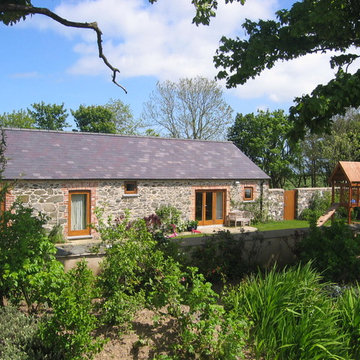 Hilltop stone farm buildings converted and extended to form modern family home