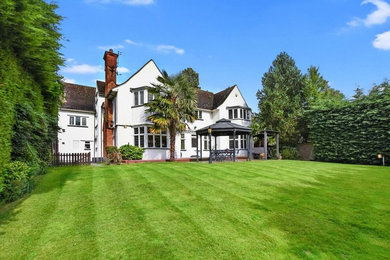 Photo of a large and white traditional detached house in Hertfordshire with three floors.