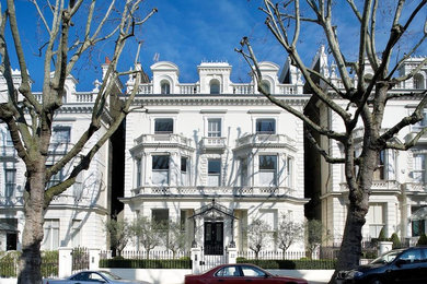 Photo of a large and white victorian render house exterior in London with three floors and a mansard roof.