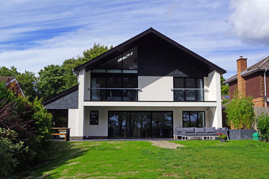 Mittelgroßes, Dreistöckiges Modernes Einfamilienhaus mit Putzfassade, weißer Fassadenfarbe, Satteldach und Ziegeldach in Wiltshire