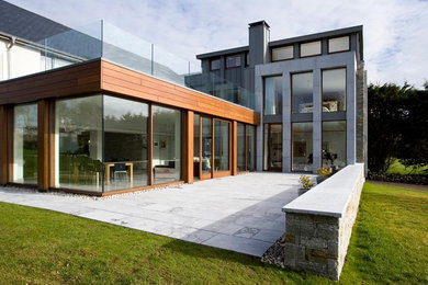 На фото: двухэтажный, серый дом в современном стиле с комбинированной облицовкой с