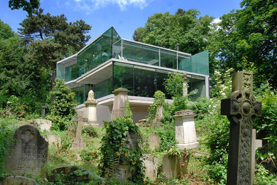 Großes, Dreistöckiges Modernes Haus mit Glasfassade und grauer Fassadenfarbe in London